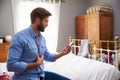 Man Sitting On Bed Getting Dressed And Checking Mobile Phone Royalty Free Stock Photo