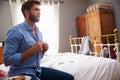 Man Sitting On Bed Getting Dressed In Morning Royalty Free Stock Photo