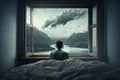Man sitting in bed and looking at the sea from the window