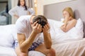 Man sitting on the bed with two women on the back