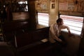 Man sitting on bench near window in suburban train in Chennai