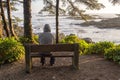 Man sitting on bench overlooking sea