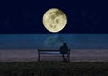 Man sitting on a bench by the sea in the  night and looking at a big shining full moon with stars reflecting in the water. Element Royalty Free Stock Photo