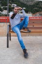 Man sitting on a bench showing his mobile phone