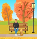 Man sitting on bench, walking with pet outdoors. Person during walk with dog in autumn park Royalty Free Stock Photo