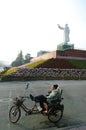 Man sitting on a bike under mao's statue, china