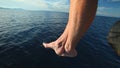 Man sitting at the bow of the boat with feet and legs overboard