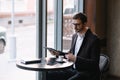 a man sitting in a cafe with tablet. Casual Man Using Tablet Computer Sitting in Cafe Surfing Internet Royalty Free Stock Photo