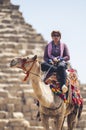 Man sitting on a camel by the pyramids in Cairo Egypt Royalty Free Stock Photo