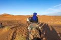 Man sitting on a camel in Sahara desert, Erg Chebbi, Merzouga, Morocco