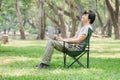 Man sitting on camping chair and working with laptop computer in the garden Royalty Free Stock Photo