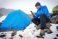 man sitting in camping tent, using smartphone Royalty Free Stock Photo