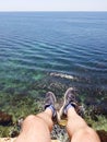 Man sitting on the Cape of the black sea. You can see the legs, the beautiful clear water, the seabed with corals