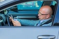 Man sitting in car with mobile phone in hand texting while driving Royalty Free Stock Photo