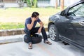 A man sitting on car wheel. A man changing tire in the park Royalty Free Stock Photo