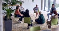 A man sitting at the center of a circle, passionately sharing his business ideas with his colleagues, fostering an Royalty Free Stock Photo