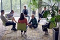 A man sitting at the center of a circle, passionately sharing his business ideas with his colleagues, fostering an Royalty Free Stock Photo