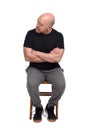 Man sitting on chair with arms crossed looking to the side Royalty Free Stock Photo