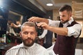 Man sitting in chair in barber shop during process of haircut Royalty Free Stock Photo