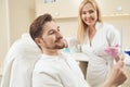 Pleased male admiring his reflection in mirror in aesthetic clinic