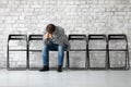 Man sitting on chair hunched after unsuccessful failed job interview Royalty Free Stock Photo