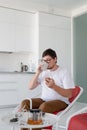Man sitting in a chair watching tv holding tea cup and phone Royalty Free Stock Photo