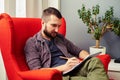 Man sitting on the chair and writing in the notebook Royalty Free Stock Photo