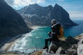 Man sitting on cliff edge alone enjoying aerial view backpacking lifestyle travel adventure outdoor vacations in Norway