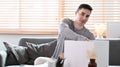 Man sitting on couch and packing belongings into carton containers preparing for moving into new house. Royalty Free Stock Photo