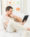 Man sitting on the couch with tablet pc Royalty Free Stock Photo