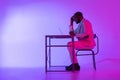 A man is sitting at a desk. A black programmer works using a laptop computer. the man works at night.