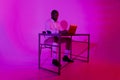 A man is sitting at a desk. A black programmer works using a laptop computer. the man works at night.