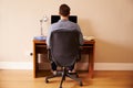 Man Sitting At Desk Working At Computer In Home Office