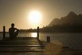 Man Sitting On Dock By Lake Royalty Free Stock Photo