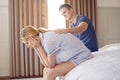 Man Sitting On End Of Bed At Home Comforting Woman Suffering With Mental Health Issues