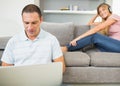 Man sitting on floor with laptop with woman listening to music o Royalty Free Stock Photo