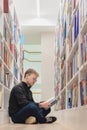 man is sitting on floor in library and reading book. education at university campus Royalty Free Stock Photo