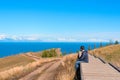 Man sitting on the floor watching on the bright blue lake Baikal. Hiking or travel concept. Exploring the great outdoors