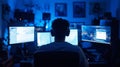 Man sitting in front of multiple computer screens in a dark room Royalty Free Stock Photo