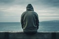 Man sitting in front of the ocean and looking at the stormy sea - Generative AI Royalty Free Stock Photo