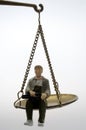 Man sitting on golden weighing scale