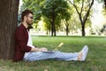 Man sitting on grass with laptop outdoors Royalty Free Stock Photo