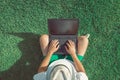 Man sitting on grass and using blank screen laptop Royalty Free Stock Photo