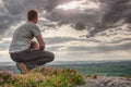 Man sitting on summit. He wear light clothes Royalty Free Stock Photo