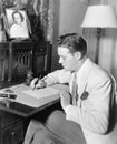 Man sitting at his desk writing a letter with a fountain pen Royalty Free Stock Photo