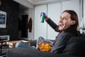 Man sitting at home indoors eating crisps watch tv Royalty Free Stock Photo