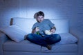 Man sitting at home sofa in living room watching movie or sport in tv eating popcorn and drinking beer Royalty Free Stock Photo