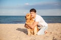 Man sitting and hugging his dog on the beach Royalty Free Stock Photo