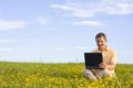 Man sitting with laptop computer in a meadow Royalty Free Stock Photo