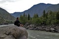 Man sitting on a large rock over mountain river Royalty Free Stock Photo